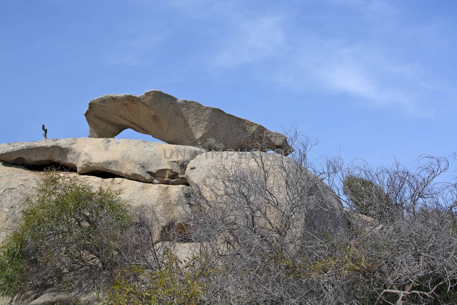 Slab of granite rock lying on top of eroded cliff by ArtesiaWells