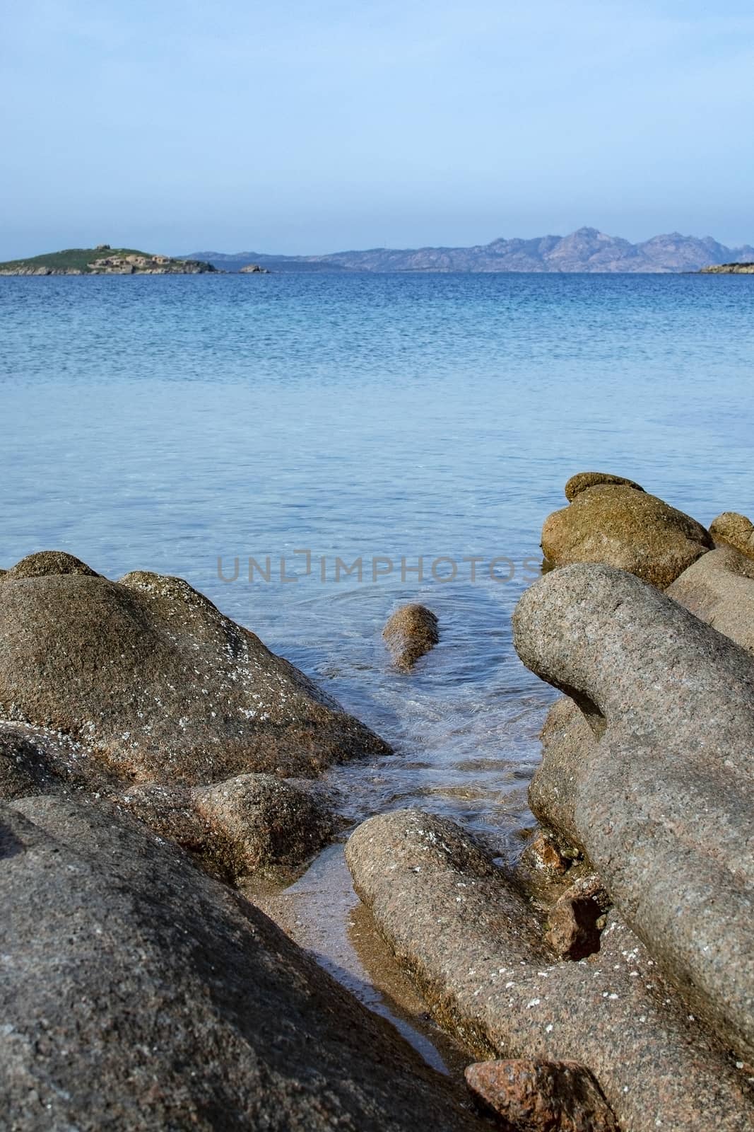 Green water and funny granite rock shapes on a beach in Costa Smeralda, Sardinia, Italy in March.