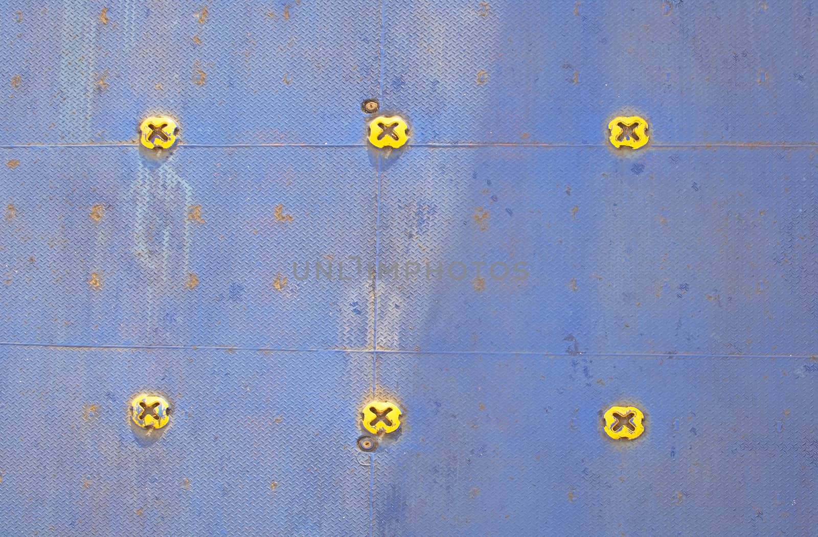 Colorful ferry car deck flooring in blue painted metal with yellow knobs.