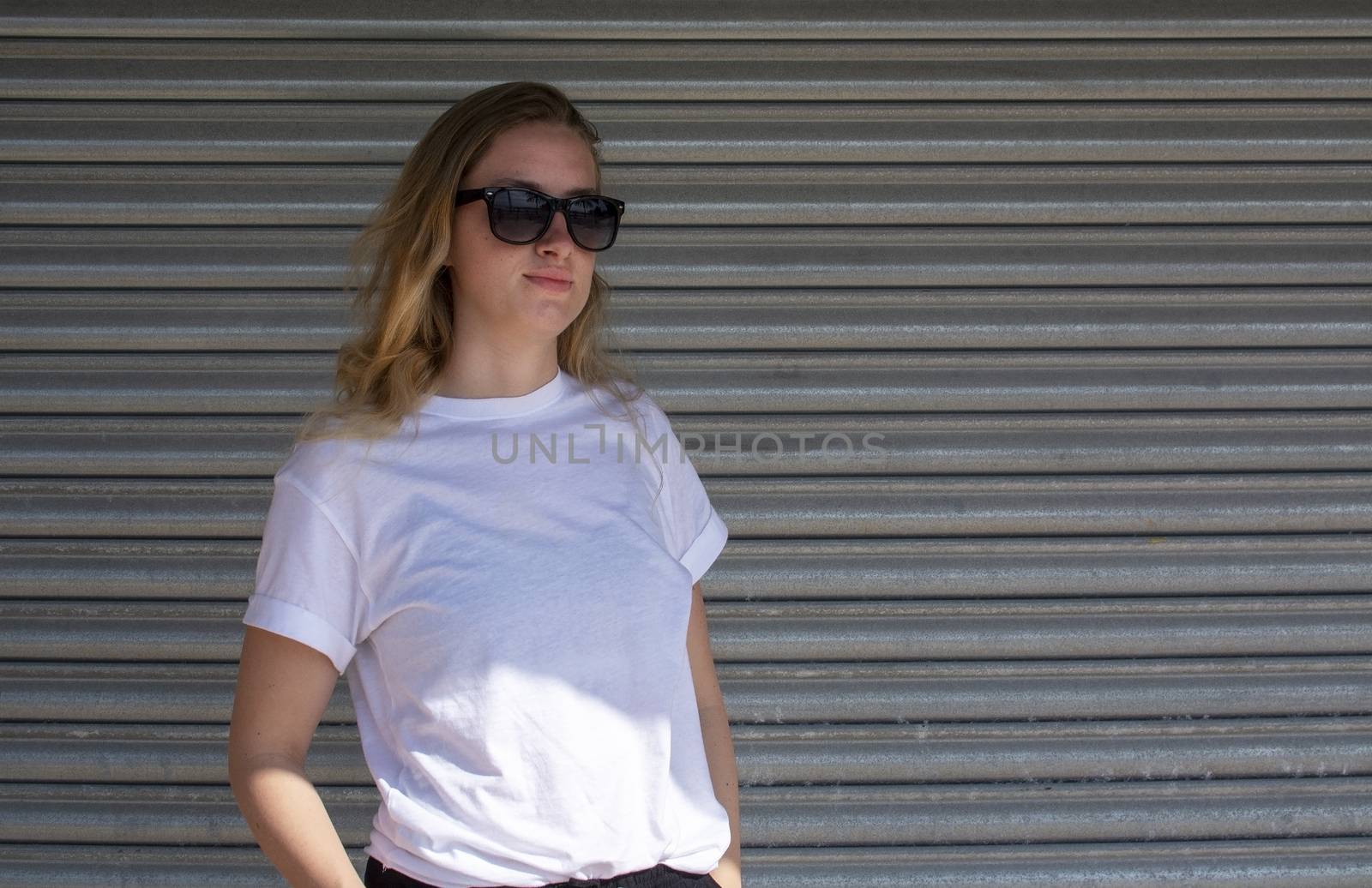 Young casual sporty dressed blonde woman with sunglasses by ArtesiaWells