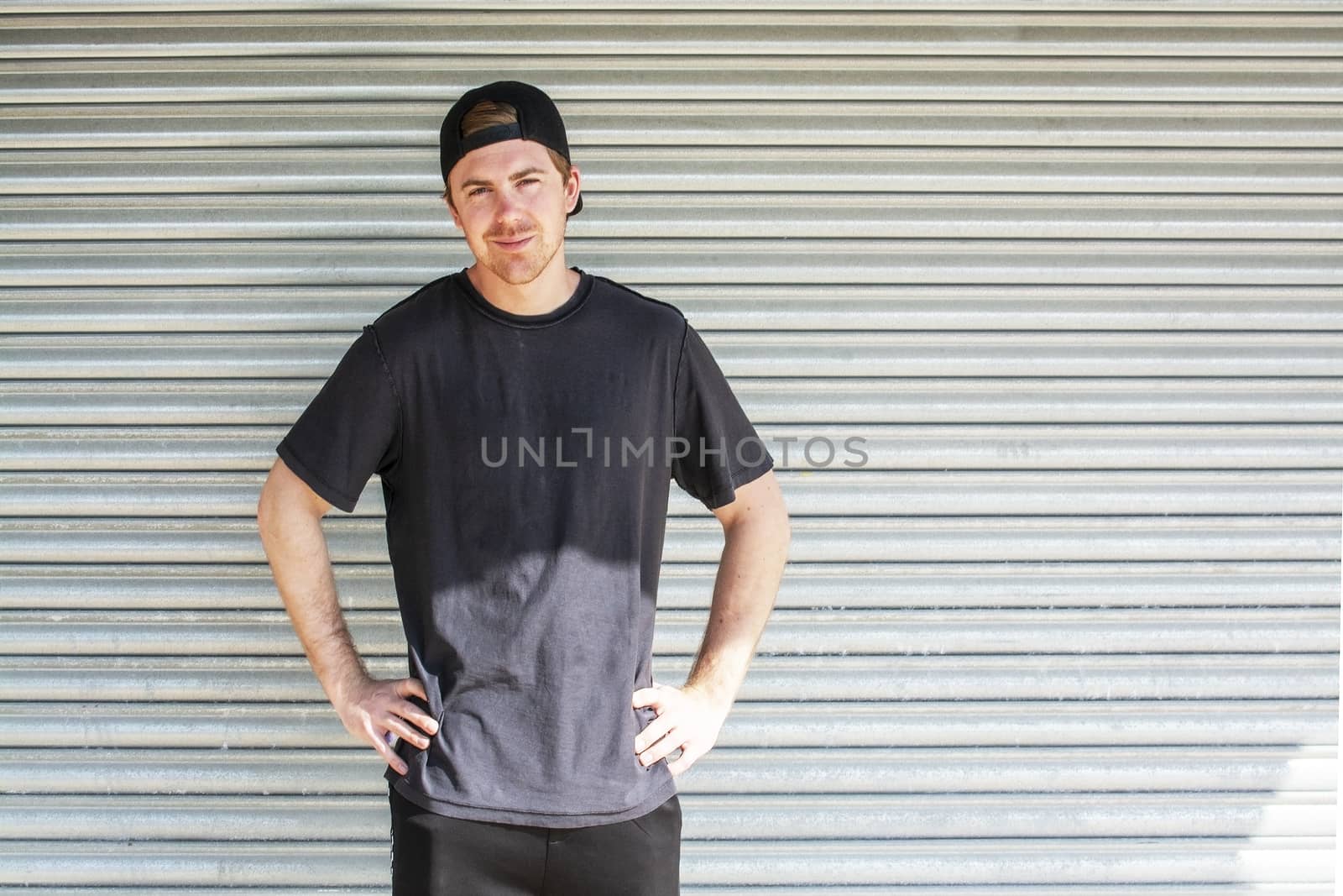 Young casual sporty dressed man with cap backwards by ArtesiaWells