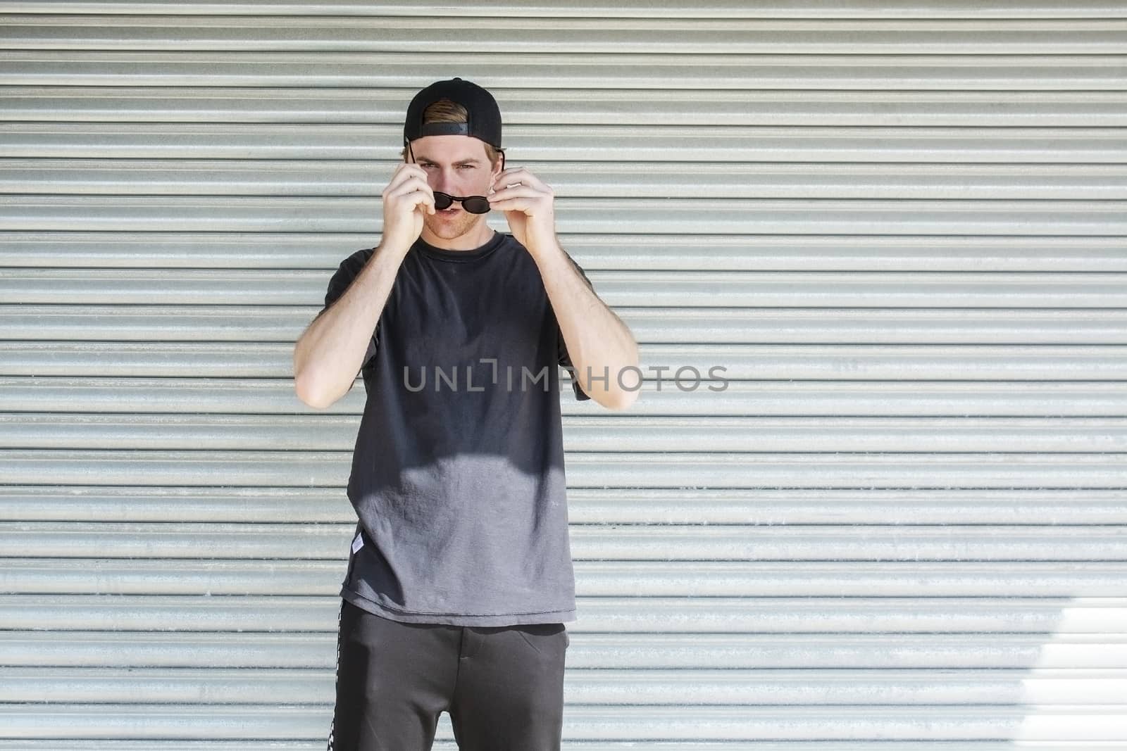 Young casual sporty dressed man with cap backwards by ArtesiaWells