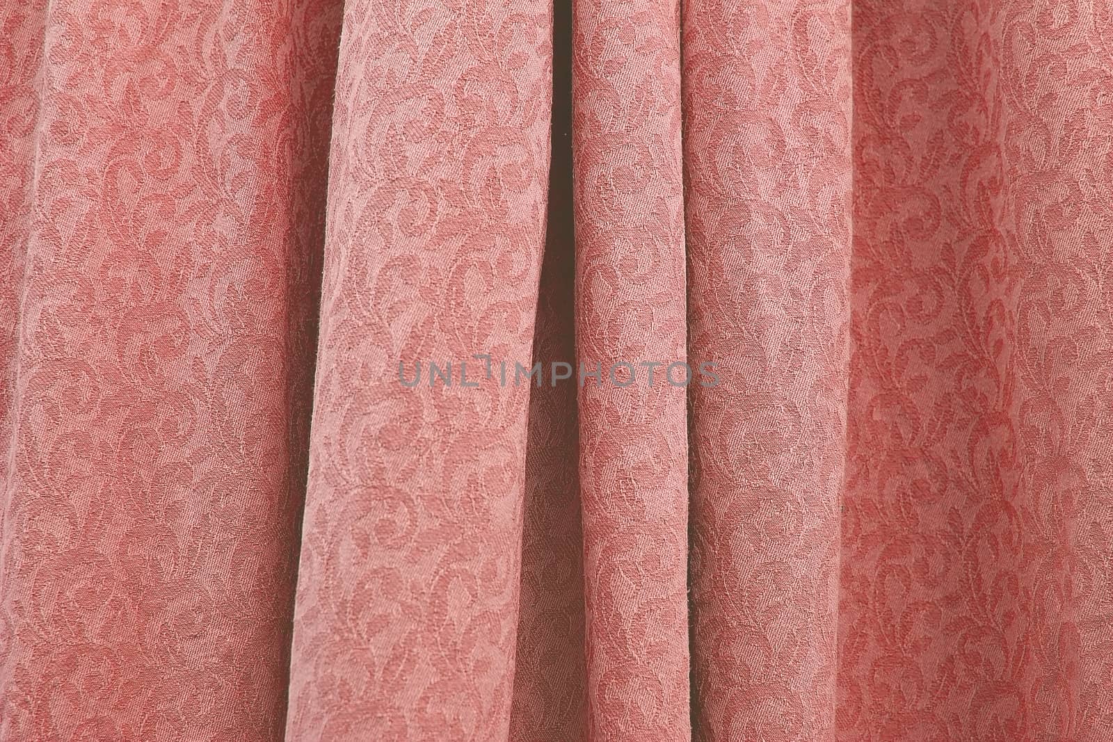 Beautiful folded damask woven cotton fabric background texture horizontal toned in trend color Living Coral.