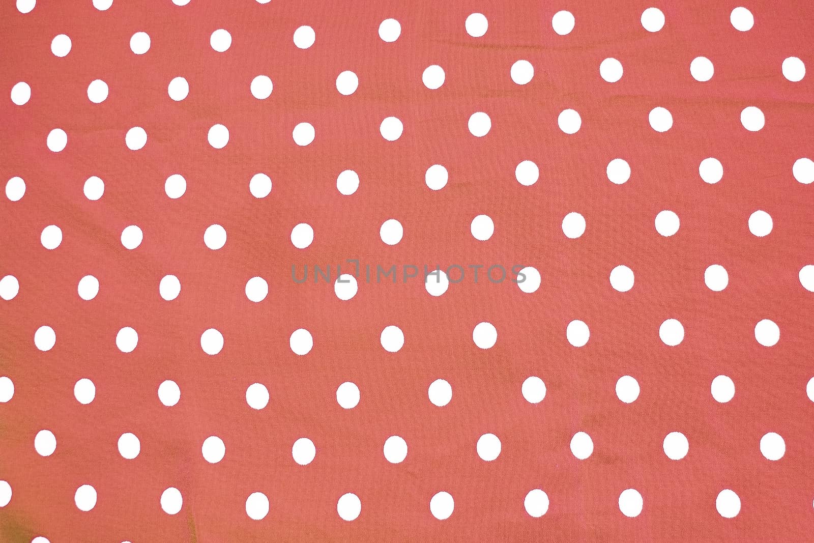 Red and white polka dot printed fabric fun romantic background texture toned in Living Coral shades 