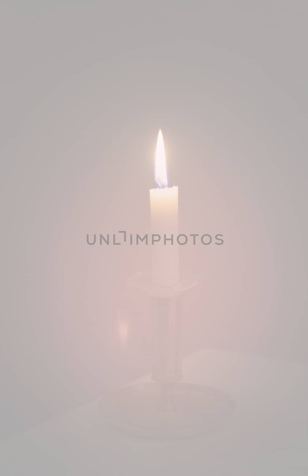 Simple candle burning in dark haze, various concepts of darkness to light, prayer symbolism, illumination, awakening and more.