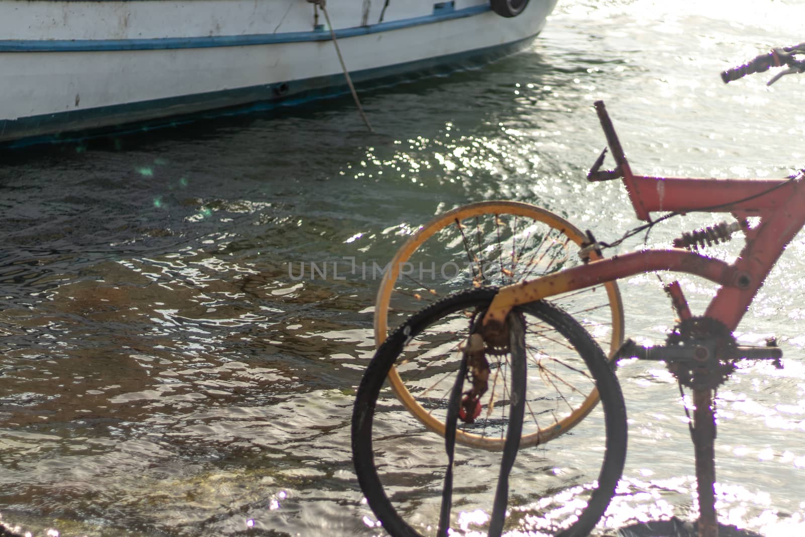 people put a bicycle at coast and a boat is there by Swonie