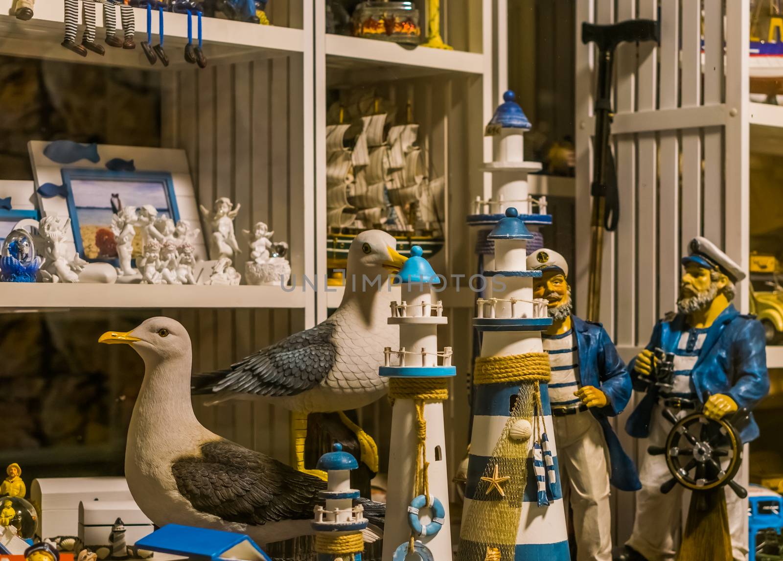 shopping window of a beach souvenir shop, sculptures of lighthouses, seagulls and sailors by charlottebleijenberg