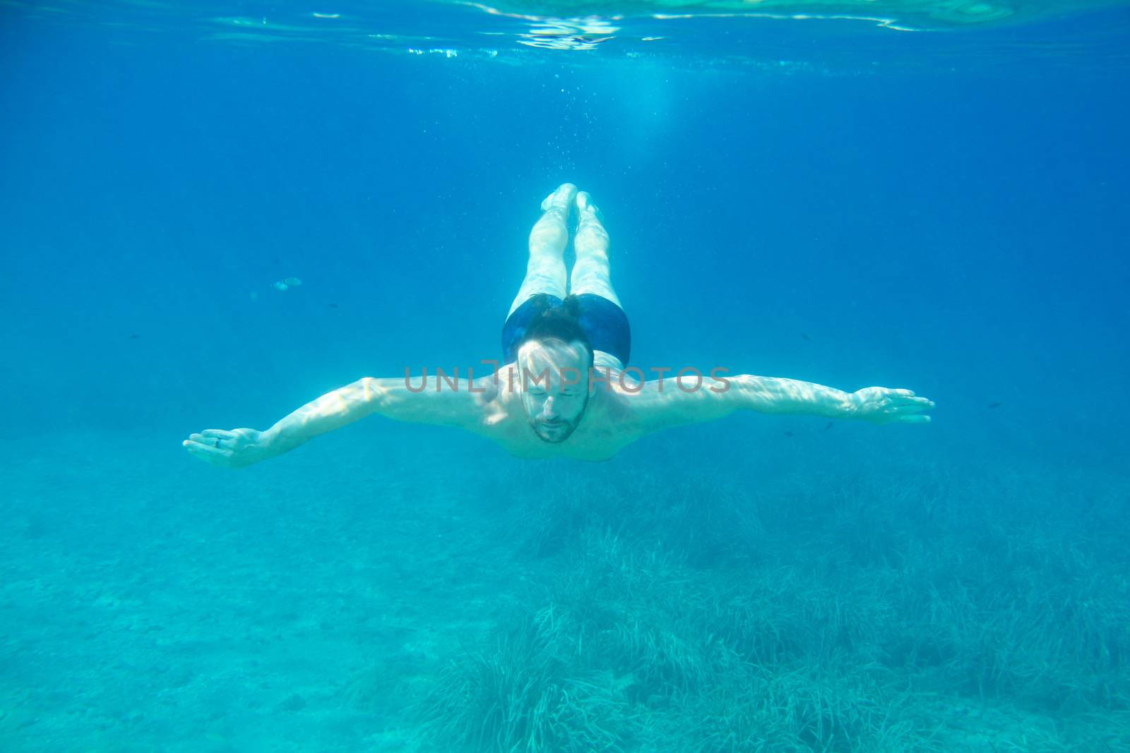 Man diving swimming underwater view by destillat