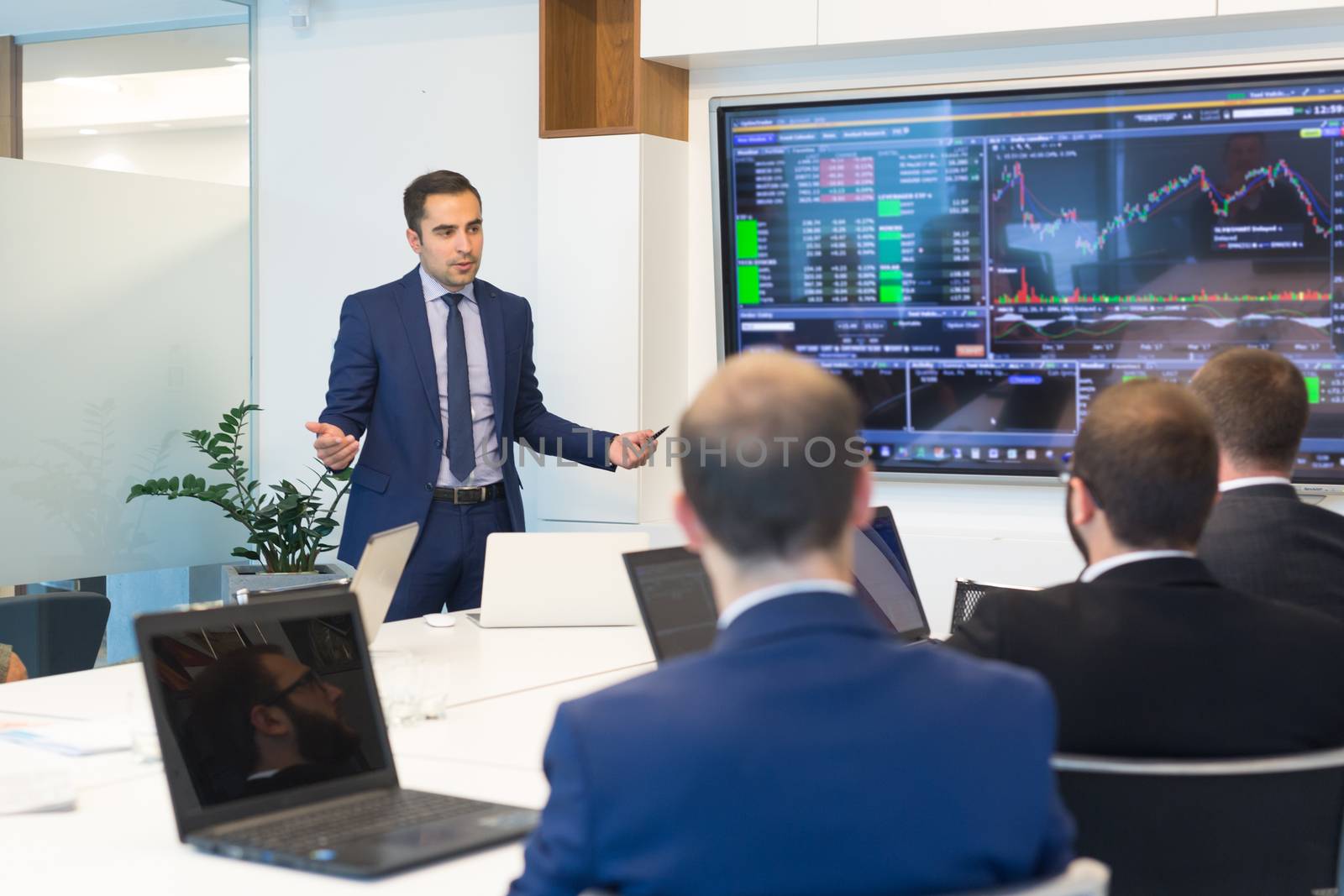 Businessman giving a talk in conference room. Business executive delivering presentation to business partners during business meeting. Corporate business concept.