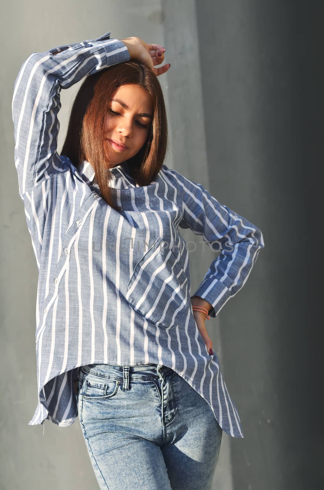 Young beautiful asian girl stands near the wall and posing and she dressed a striped shirt by xzgorik
