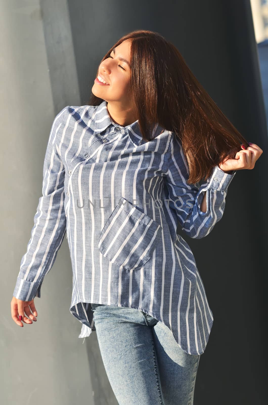 Portrait's young cool asian girl stands near the wall and posing and she dressed a striped shirt by xzgorik