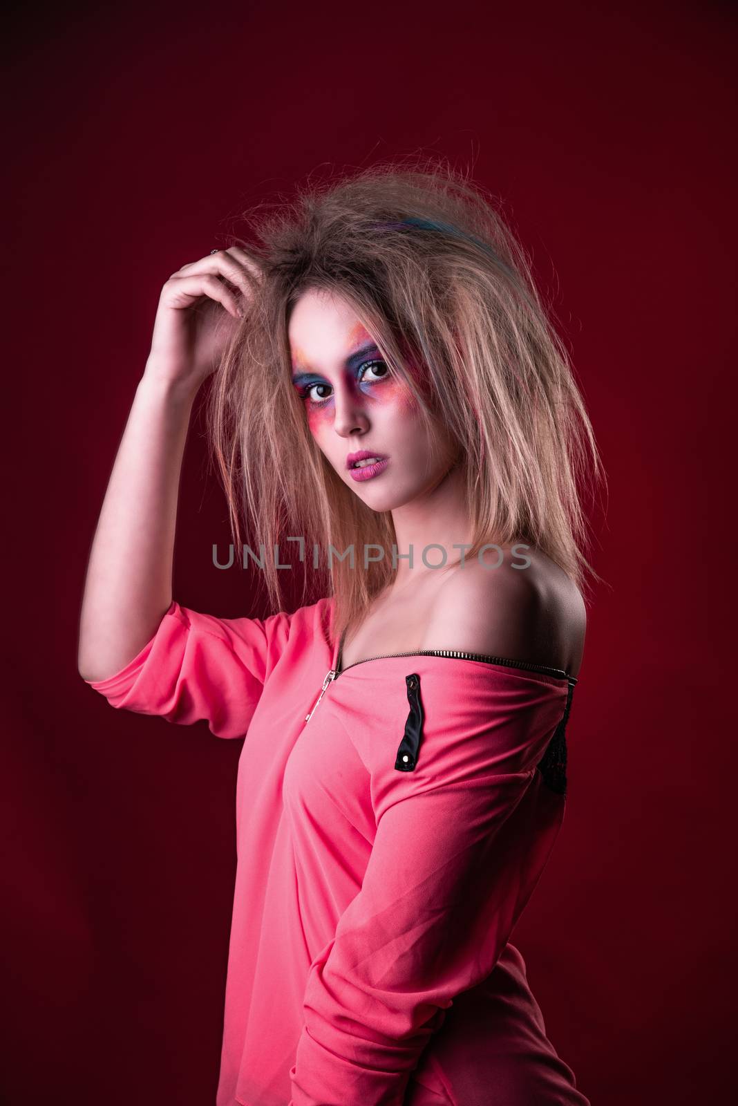 Emotional Portrait of a Attractive young girl with carnival colorful makeup and disheveled hair