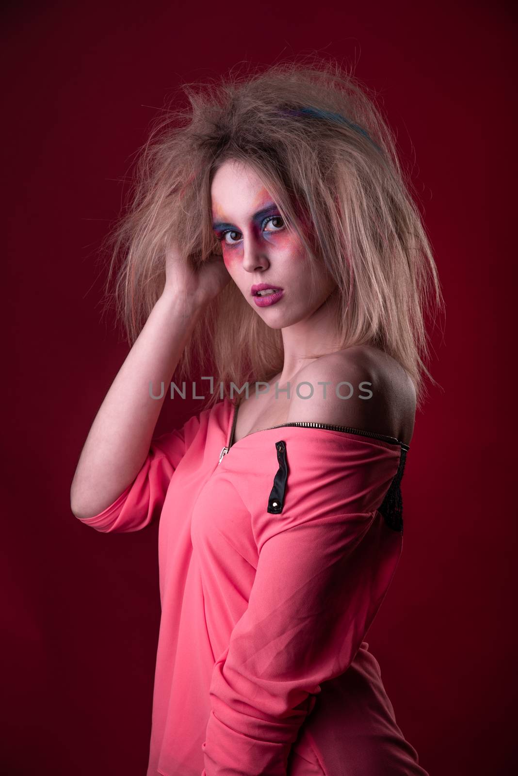 Emotional Portrait of a Attractive young girl with carnival colorful makeup and disheveled hair