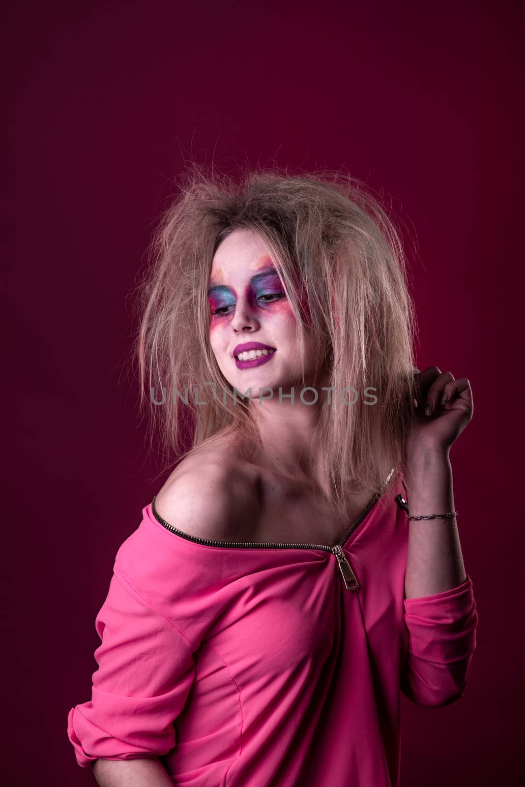 Emotional Portrait of a Attractive young girl with carnival colorful makeup and disheveled hair