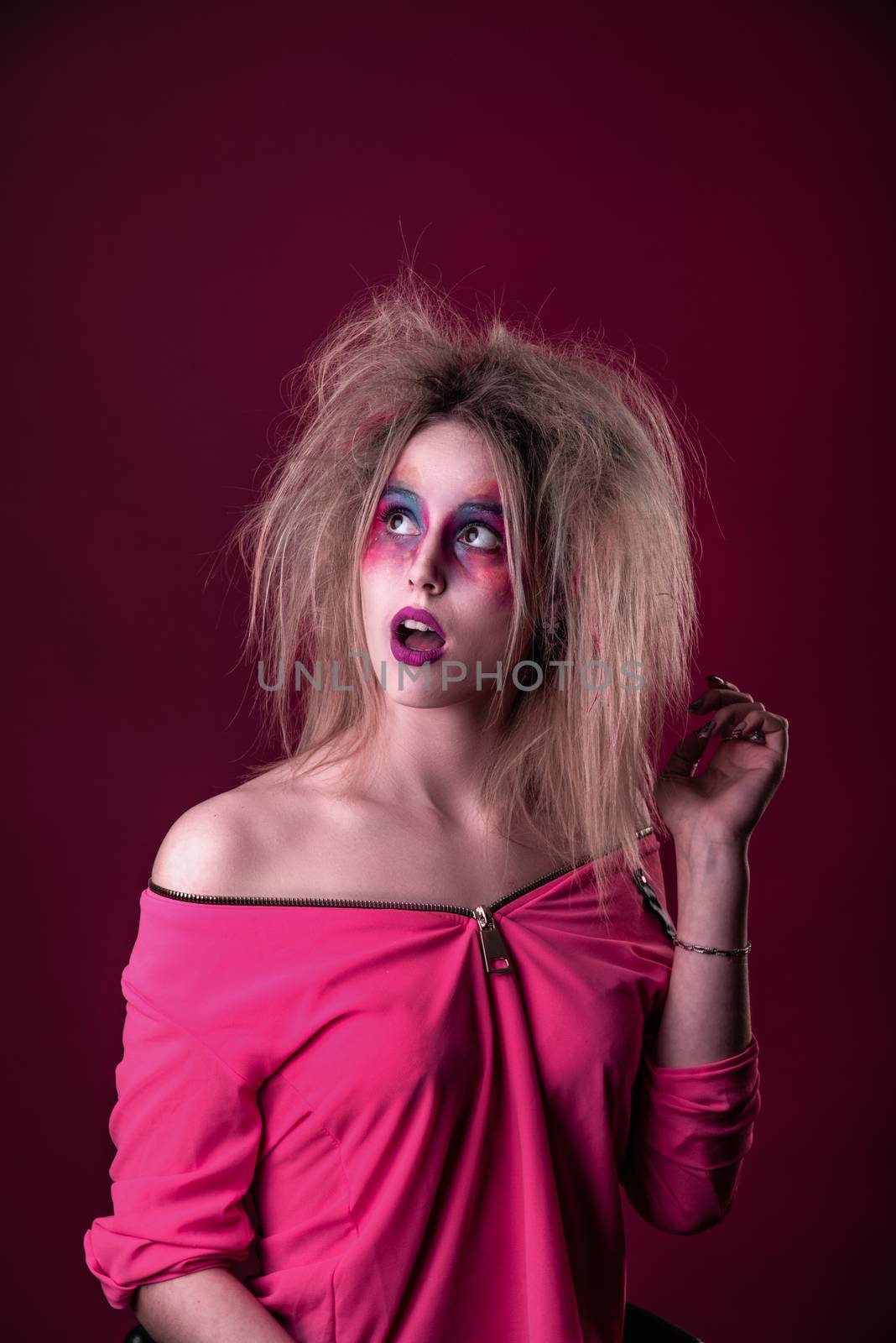 Emotional Portrait of a Attractive young girl with carnival colorful makeup and disheveled hair