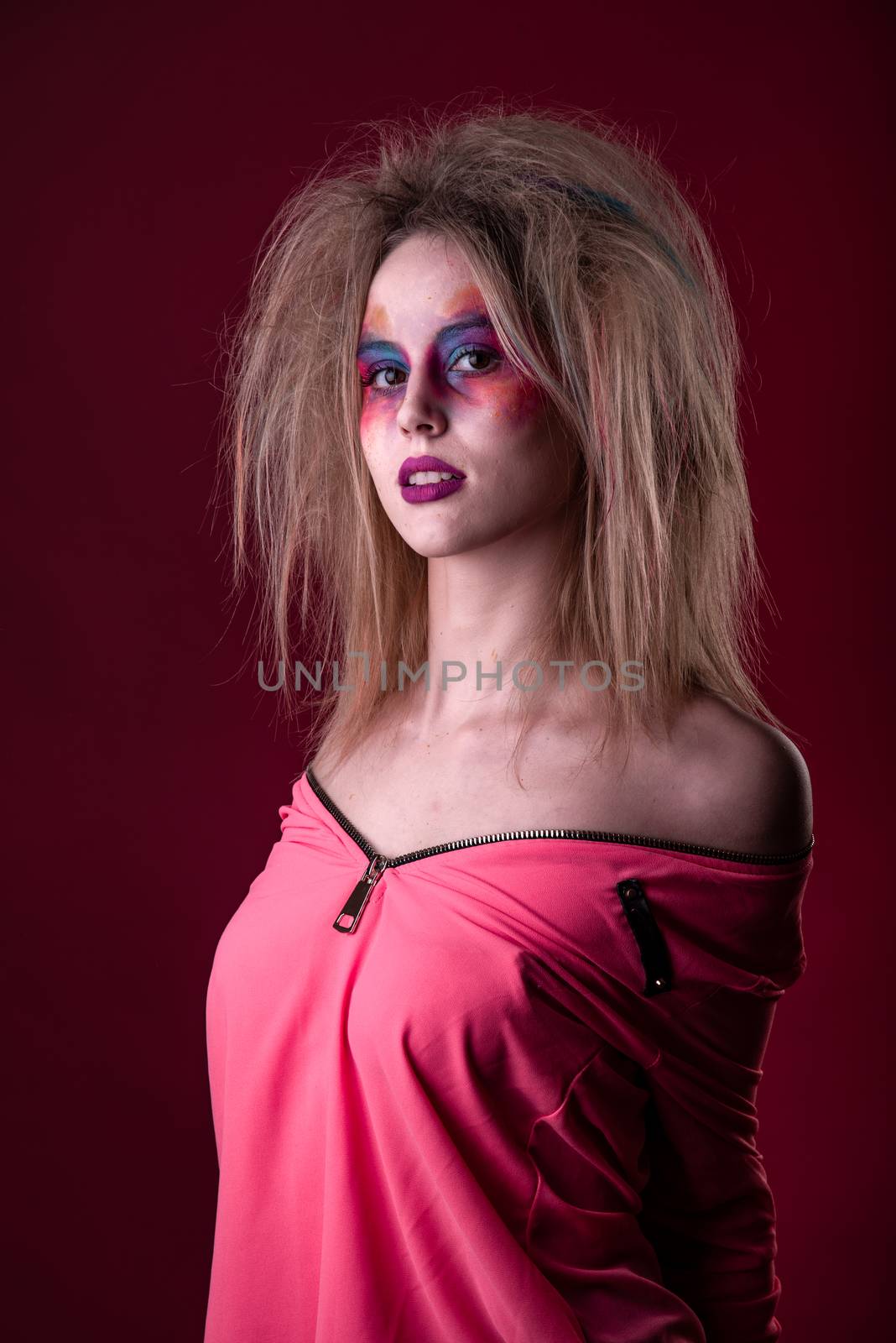 Emotional Portrait of a Attractive young girl with carnival colorful makeup and disheveled hair