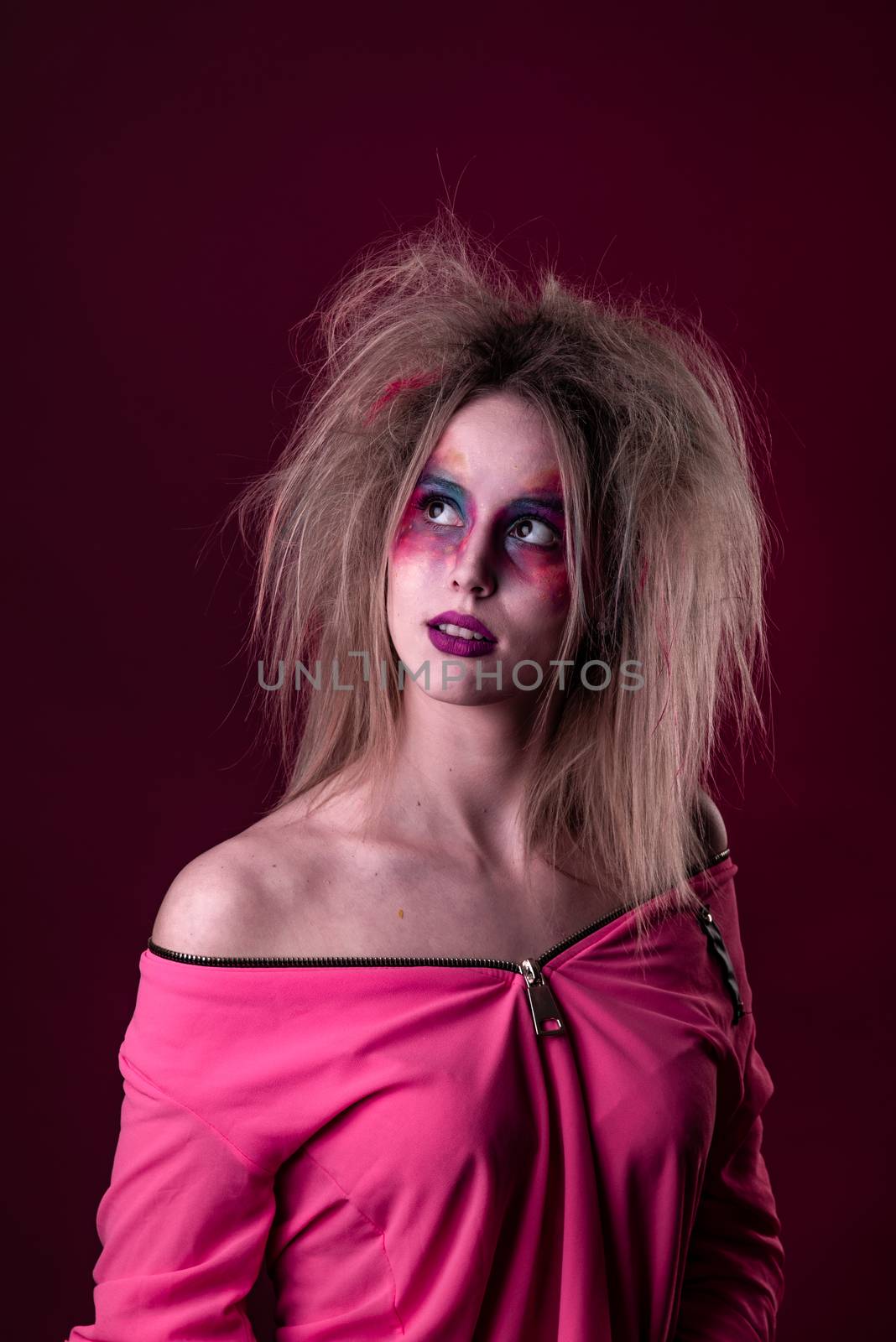 Emotional Portrait of a Attractive young girl with carnival colorful makeup and disheveled hair