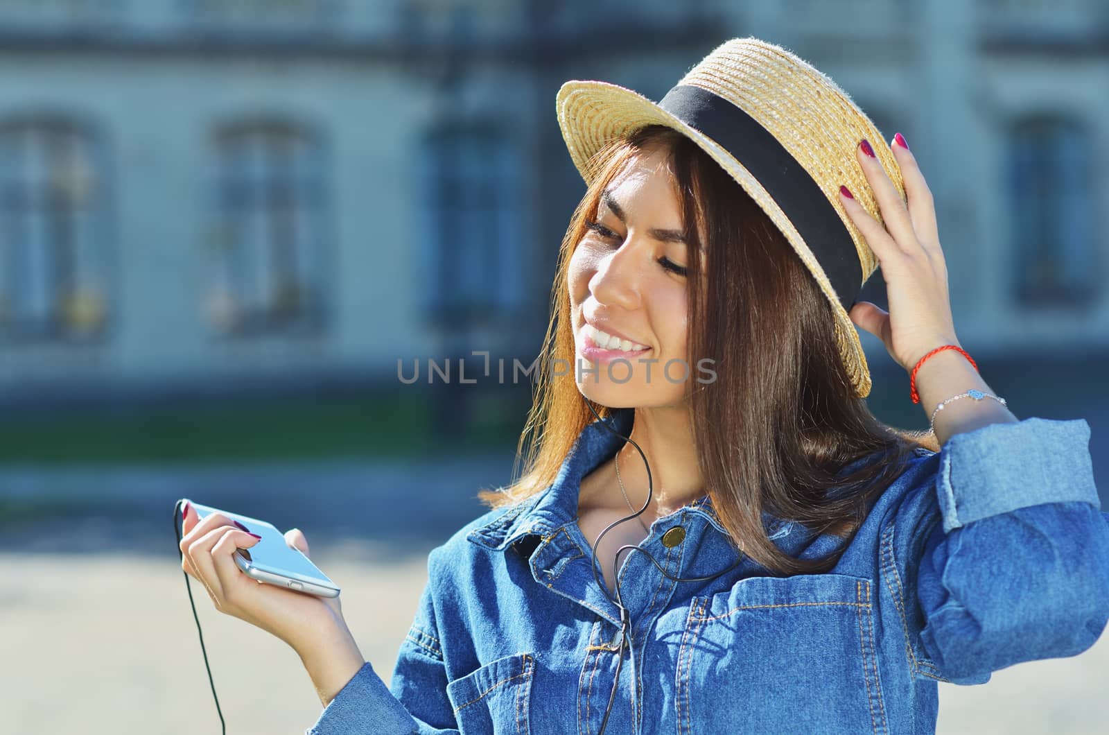 Young girl attractive appearance listening to music in the city by xzgorik