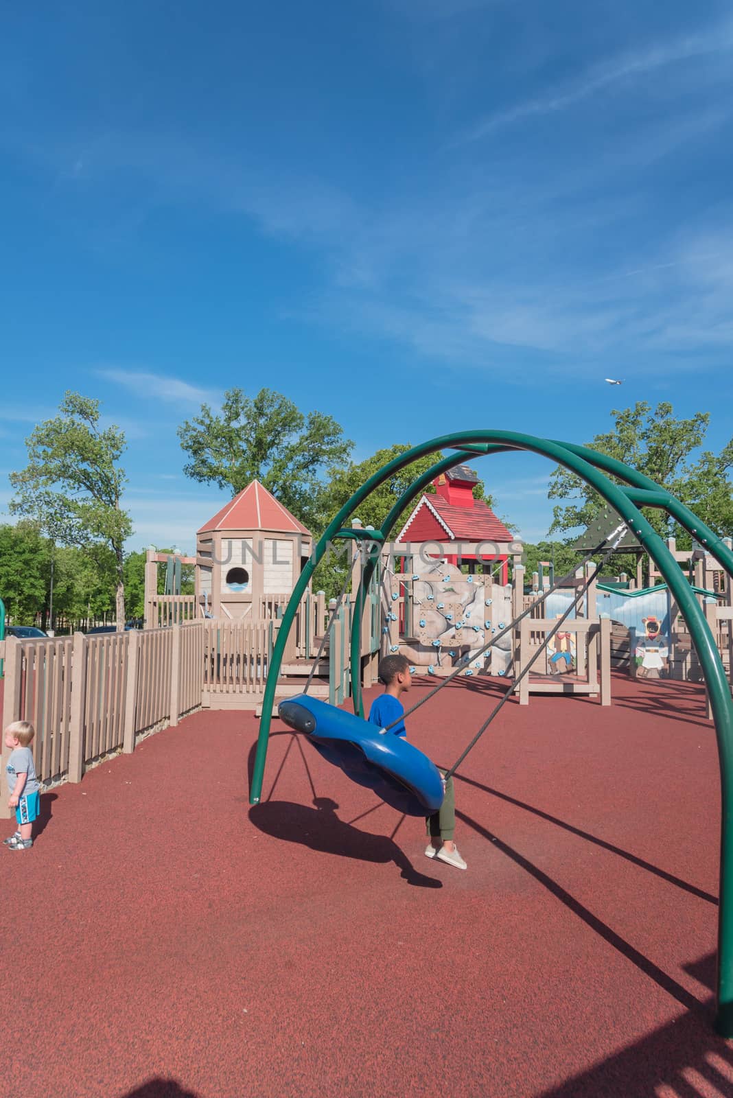 Children playing at wooden playground recreation area in America by trongnguyen