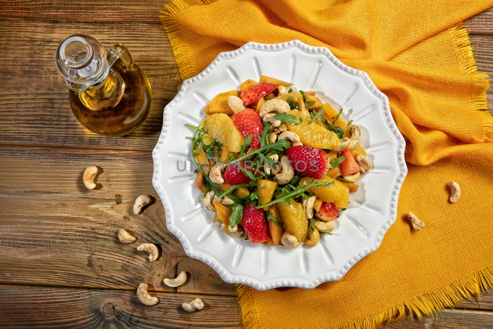 Plate with salad on a wooden desk and fabric