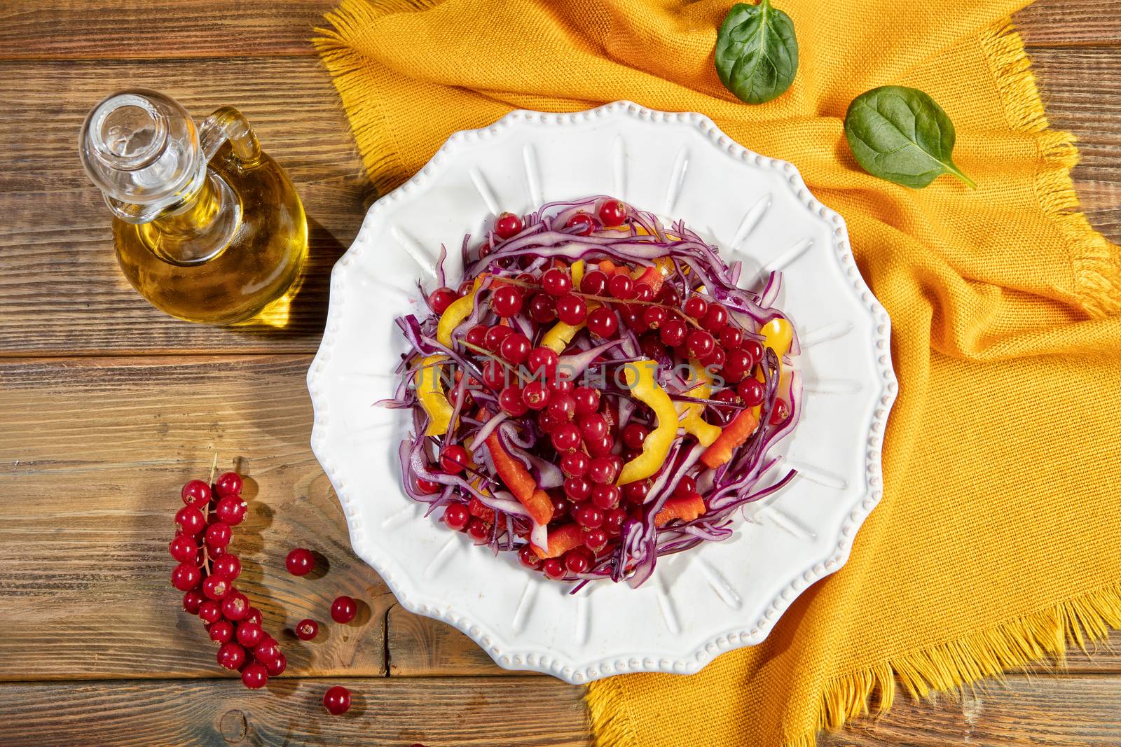 Plate with salad on a wooden desk and fabric