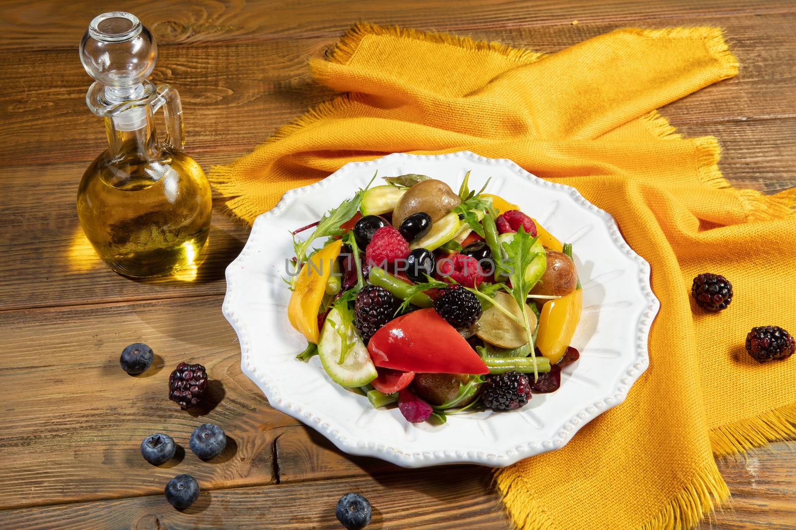 Plate with salad on a wooden desk and fabric