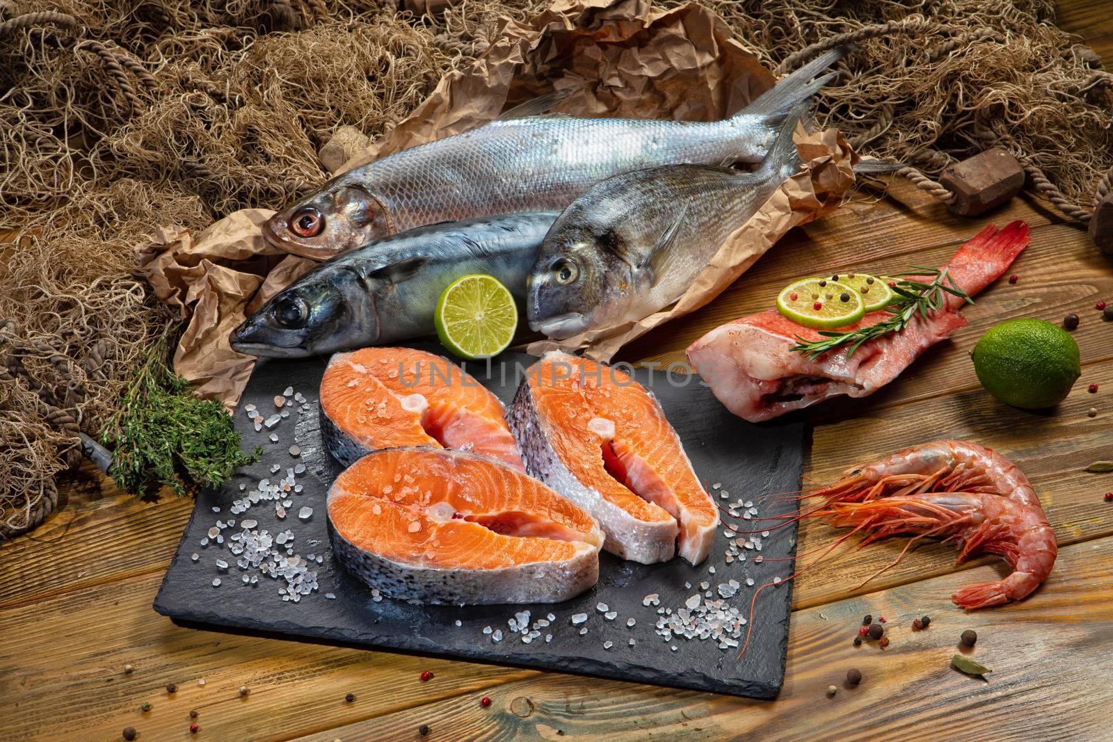 Red fish and limes on an old wooden desk
