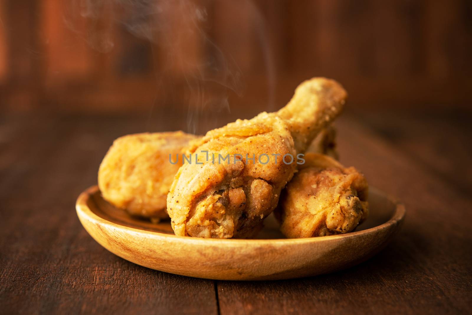 Plate of original recipe fried chickens, on dark wooden background.
