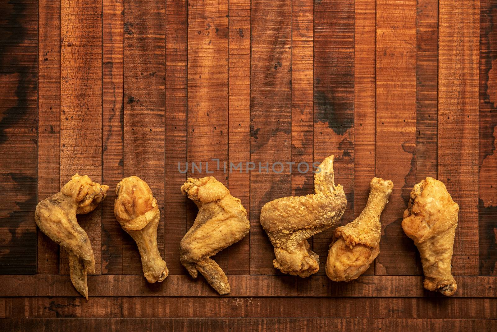 Top view flat lay original recipe fried chickens with copy space, on dark wooden background.