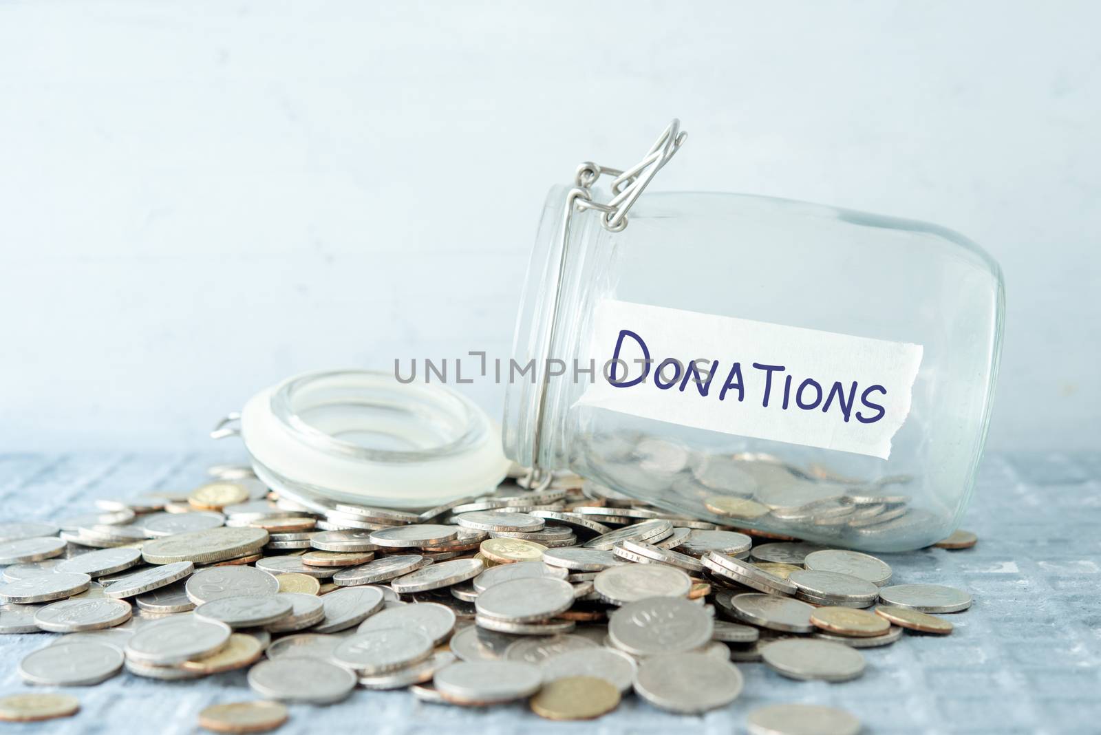 Coins and glass money jar with donations label, financial concept.