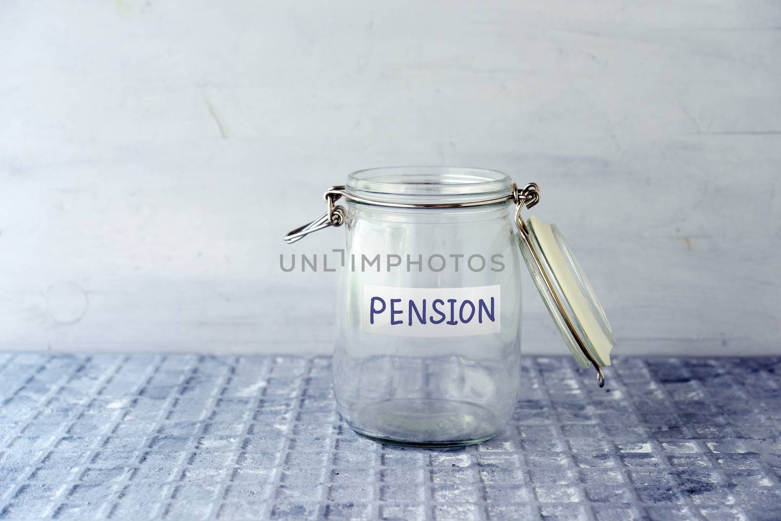 Empty glass money jar with pension label, financial concept. 