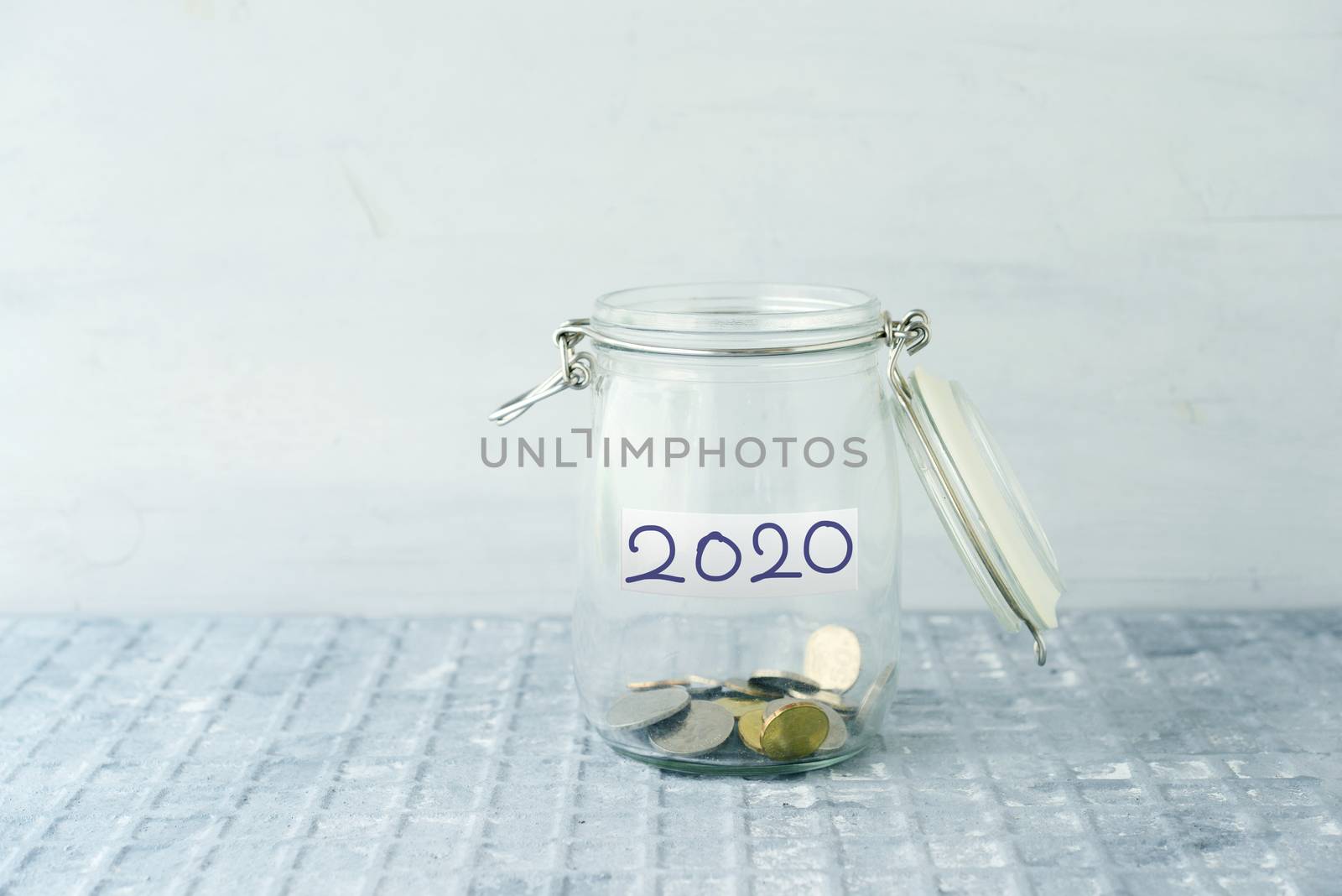 Empty glass money jar with 2020 label, financial concept.