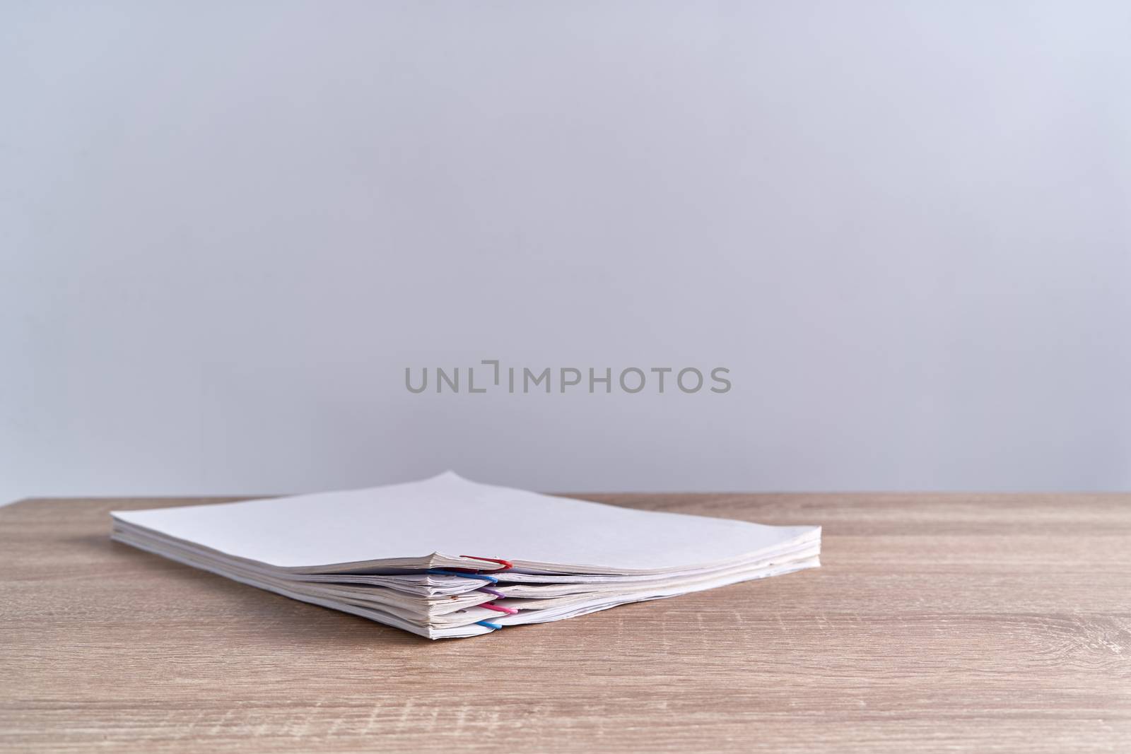 Pile document of report with colorful paperclip place on wood table and white background with copy space. Business and finance concepts successful photography.