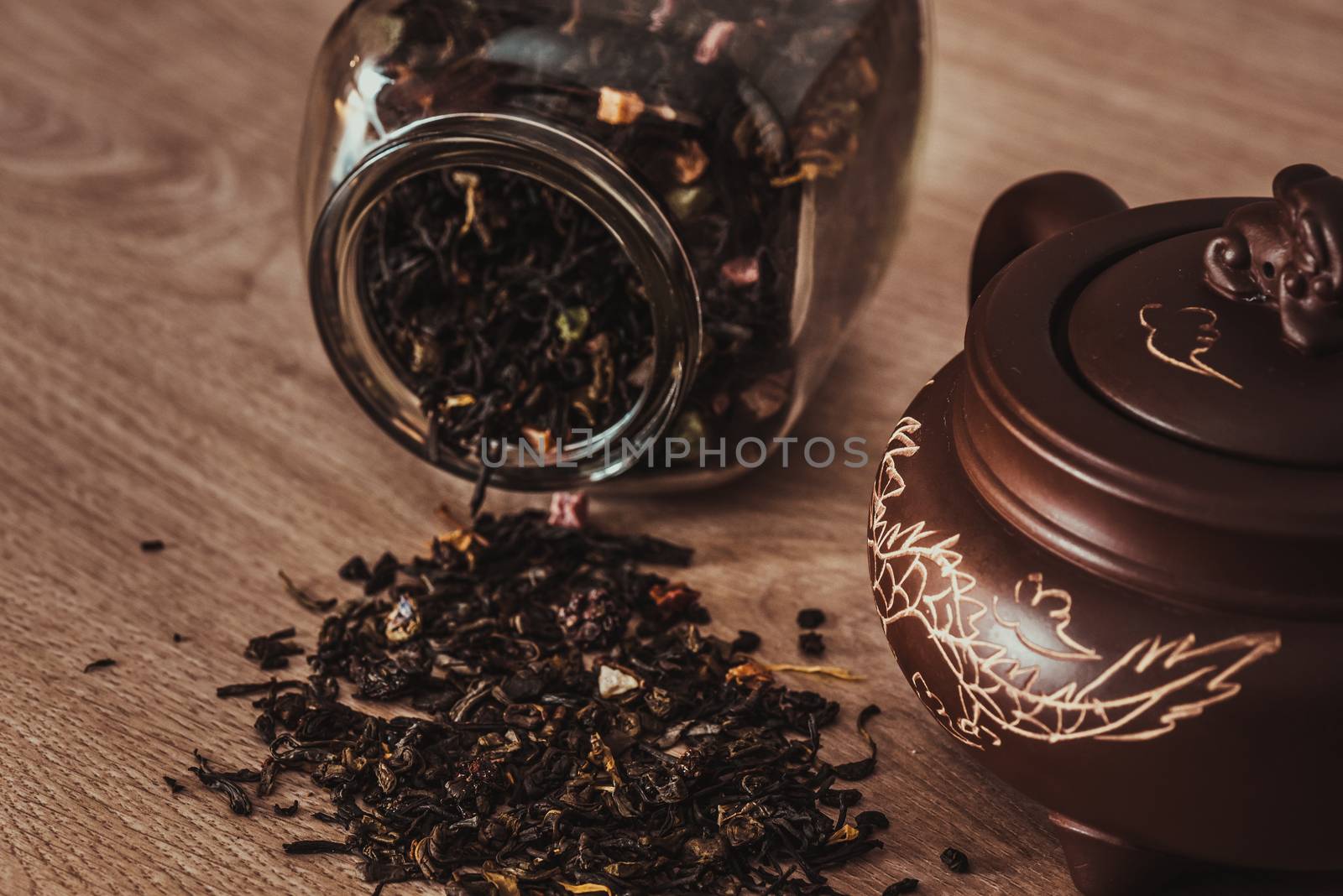 Asian teapot on stand and jar with scattering of tea by Seva_blsv