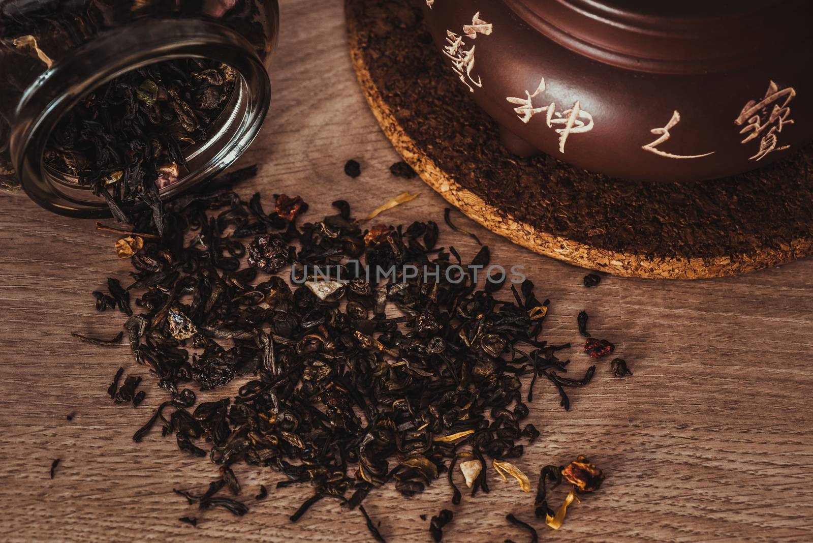 Asian teapot on stand and jar with scattering of tea by Seva_blsv