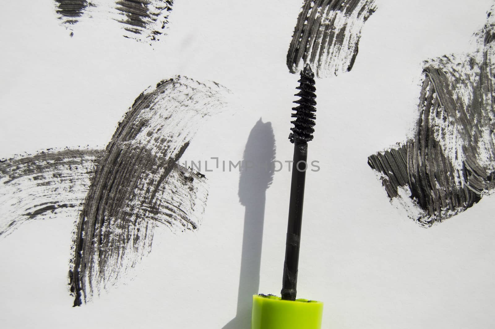 Black ink smear and green brush isolated on white.