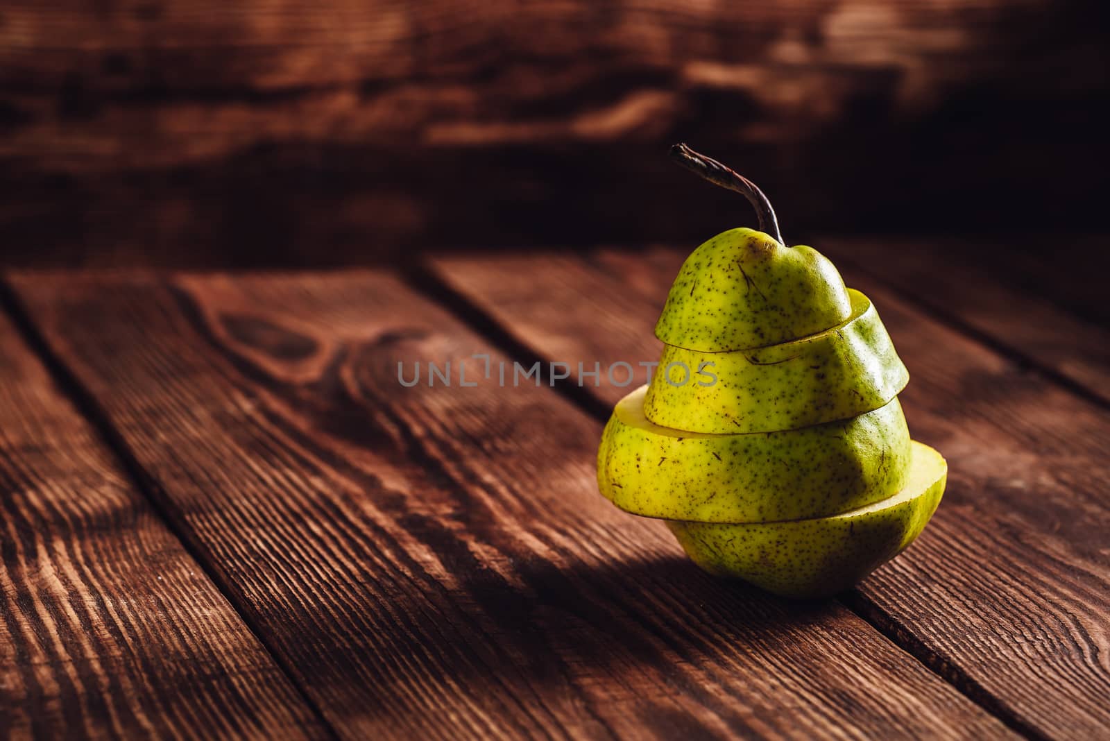 Sliced Pear on Wooden Background. Slices Stacked on Each Other. Space for Text.