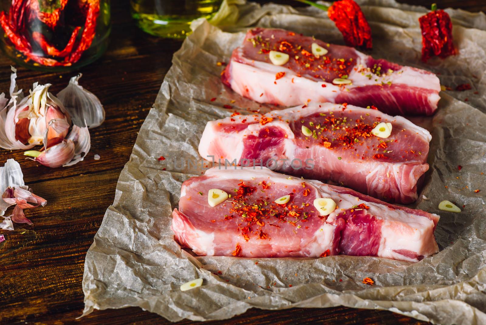 Raw pork steaks with chili pepper and garlic