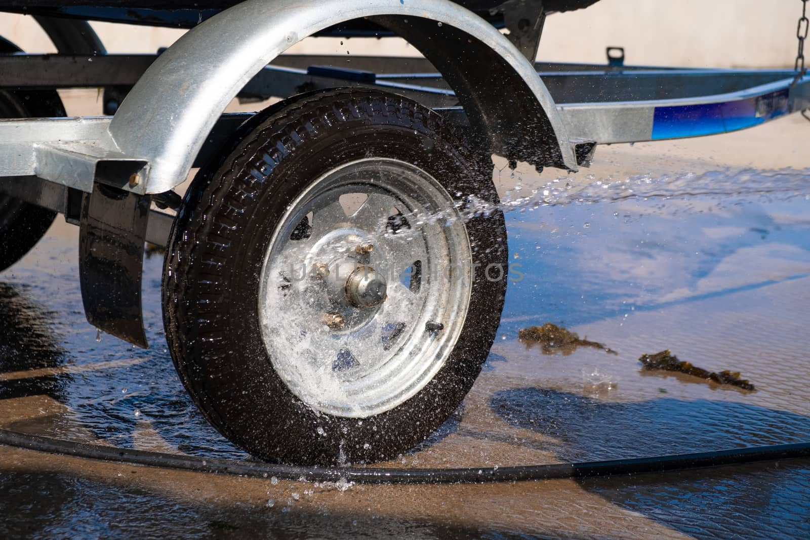 A man washes a rubber hose boat after going to sea. Drops of water scatter from the boat. by rdv27