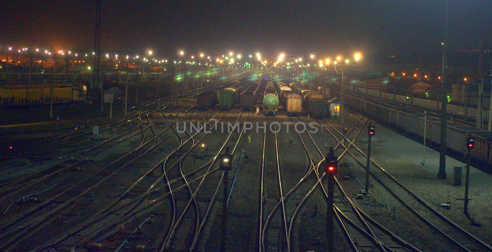 Night shooting of the crossing on the railway tracks, the bridging of the roads at the station flickers in the lights. Blur.
