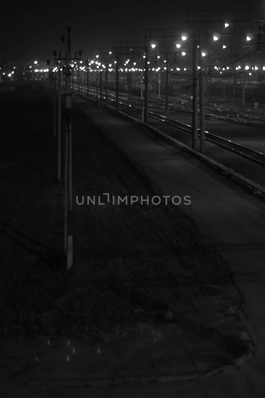 Night shooting of the crossing on the railway tracks, the bridging of the roads at the station flickers in the lights. Blur.