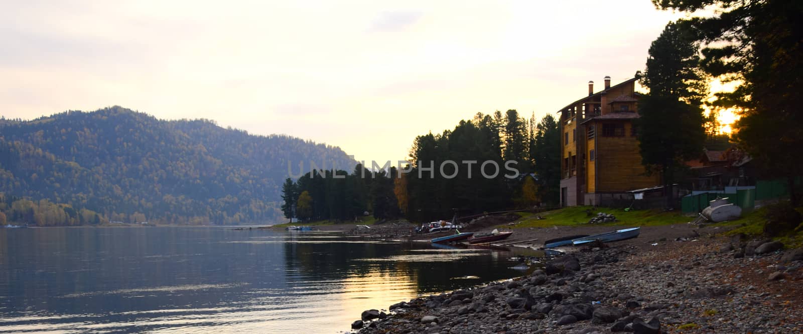 East rocky shore of Lake Teletskoye, cliffs covered with a beautiful forest. The picture was taken on an autumn day, with natural light.