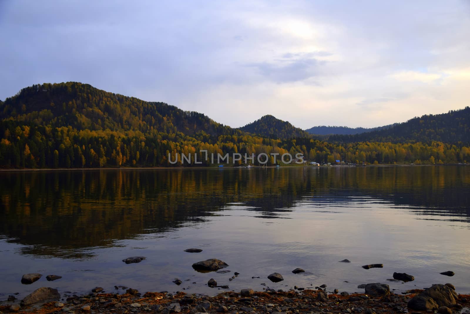 East rocky shore of Lake Teletskoye, cliffs covered with a beautiful forest. The picture was taken on an autumn day, with natural light.