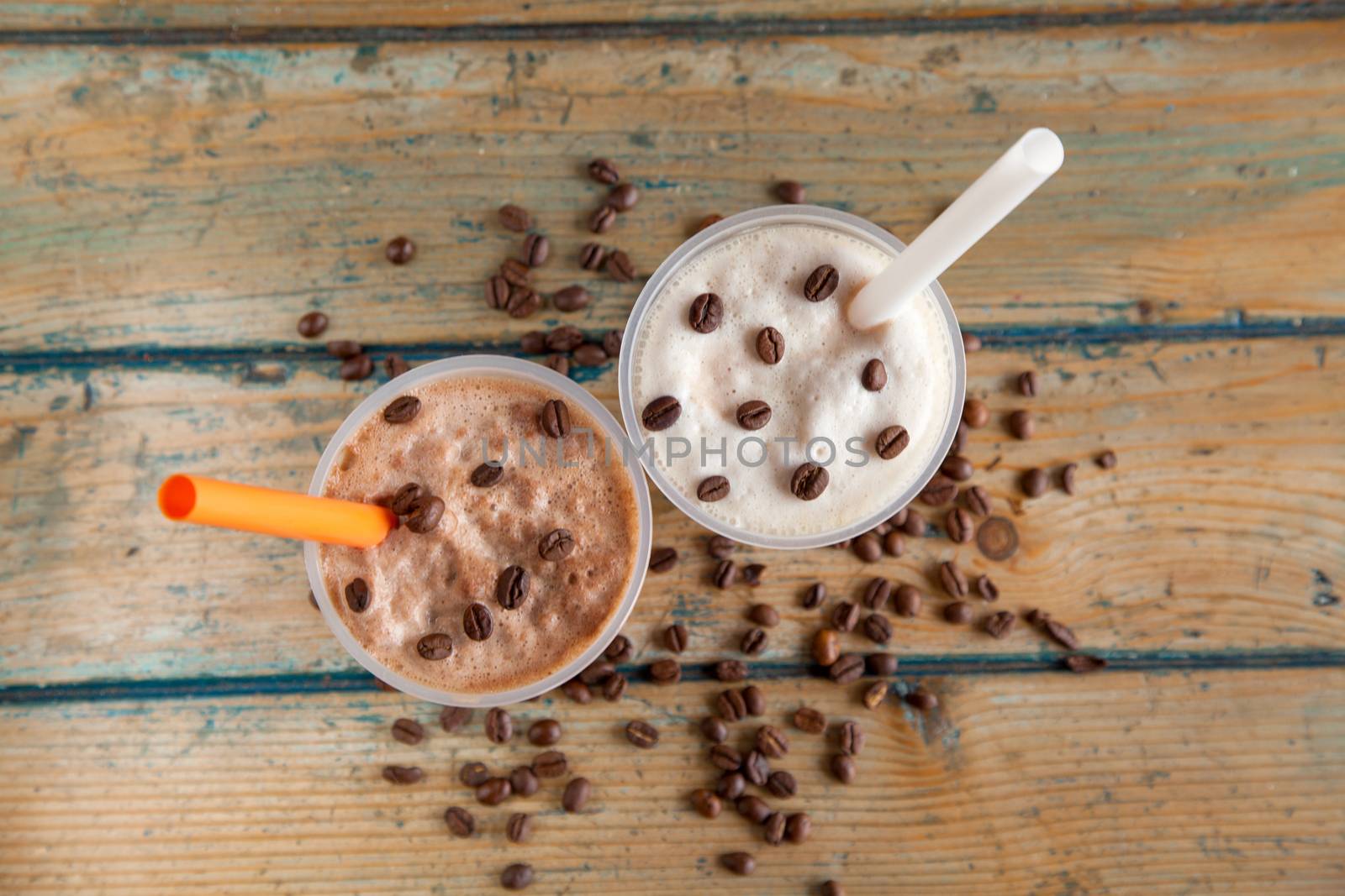 Iced frappes with coffee beans spilled top angle by haiderazim