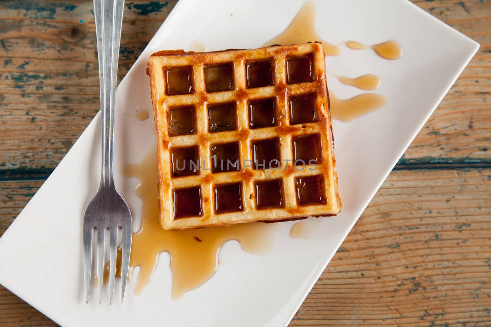 Waffle with maple syrup fork plate top angle by haiderazim