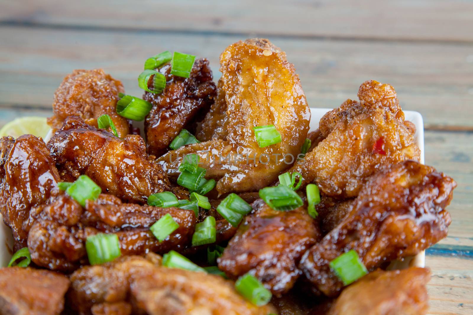 Lemon tantalising chicken wings in square bowl Close up