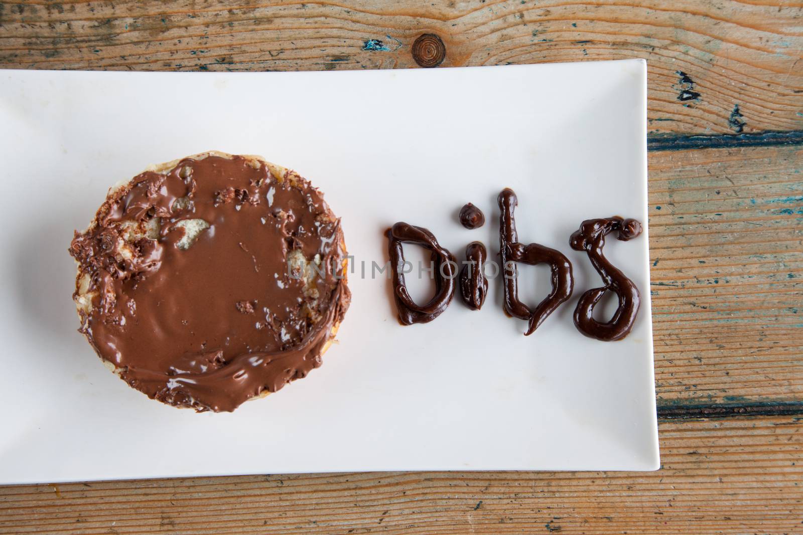 Dibs written with chocolate fudge nutella spread on bun donut by haiderazim