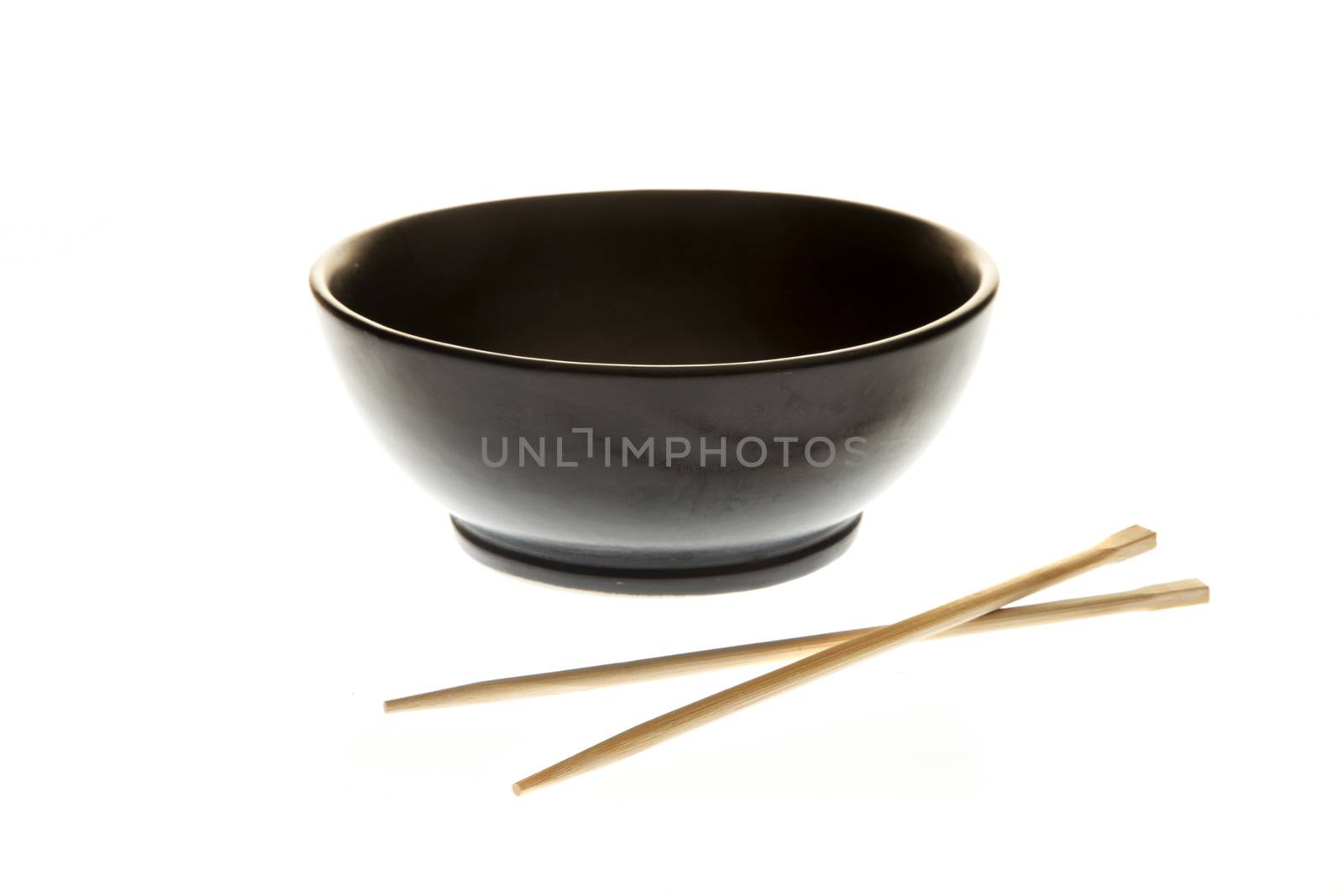 Black empty noodle bowl with chopsticks isolated on a white background