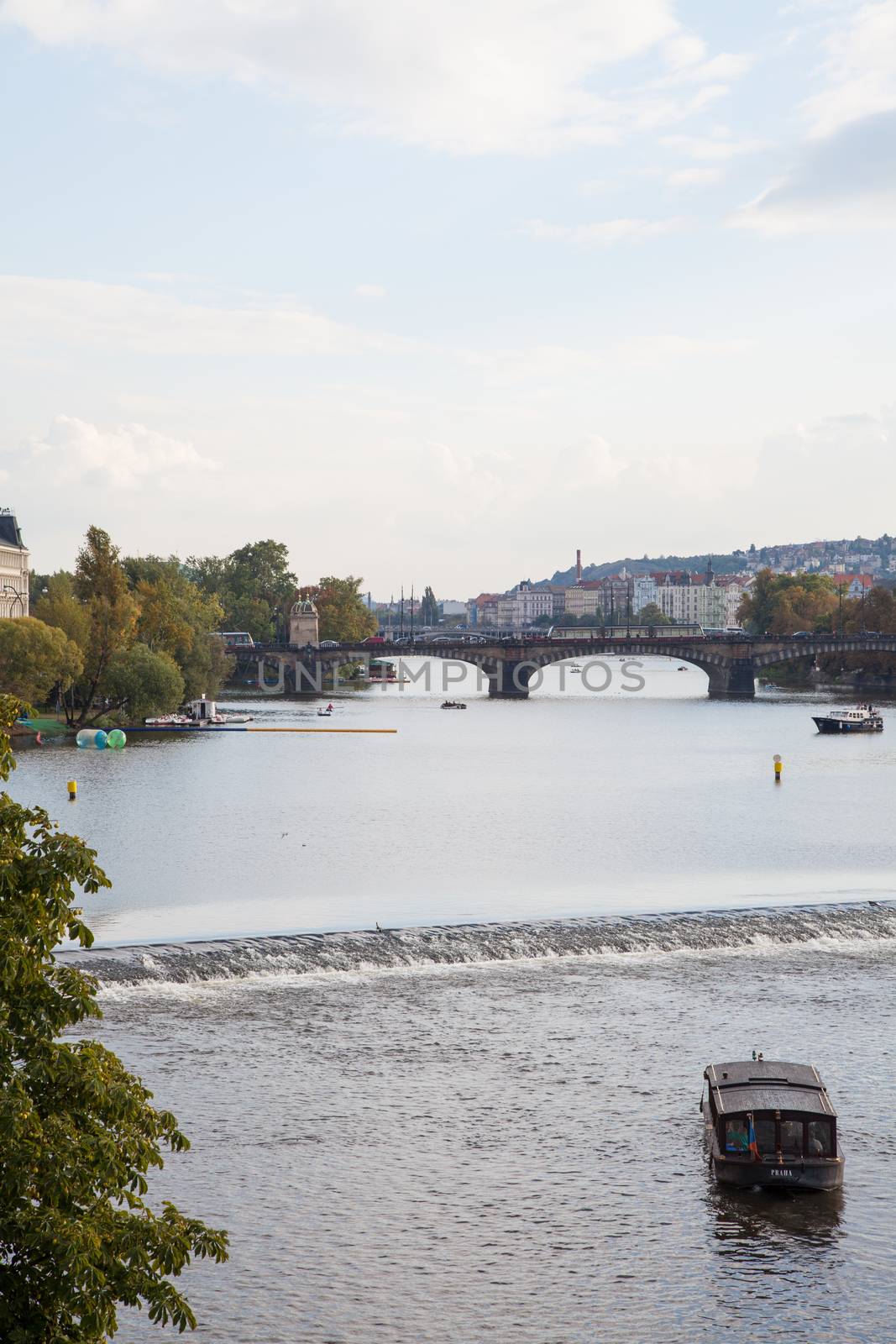 Beautiful Prague City View along the river with tourist boat by haiderazim