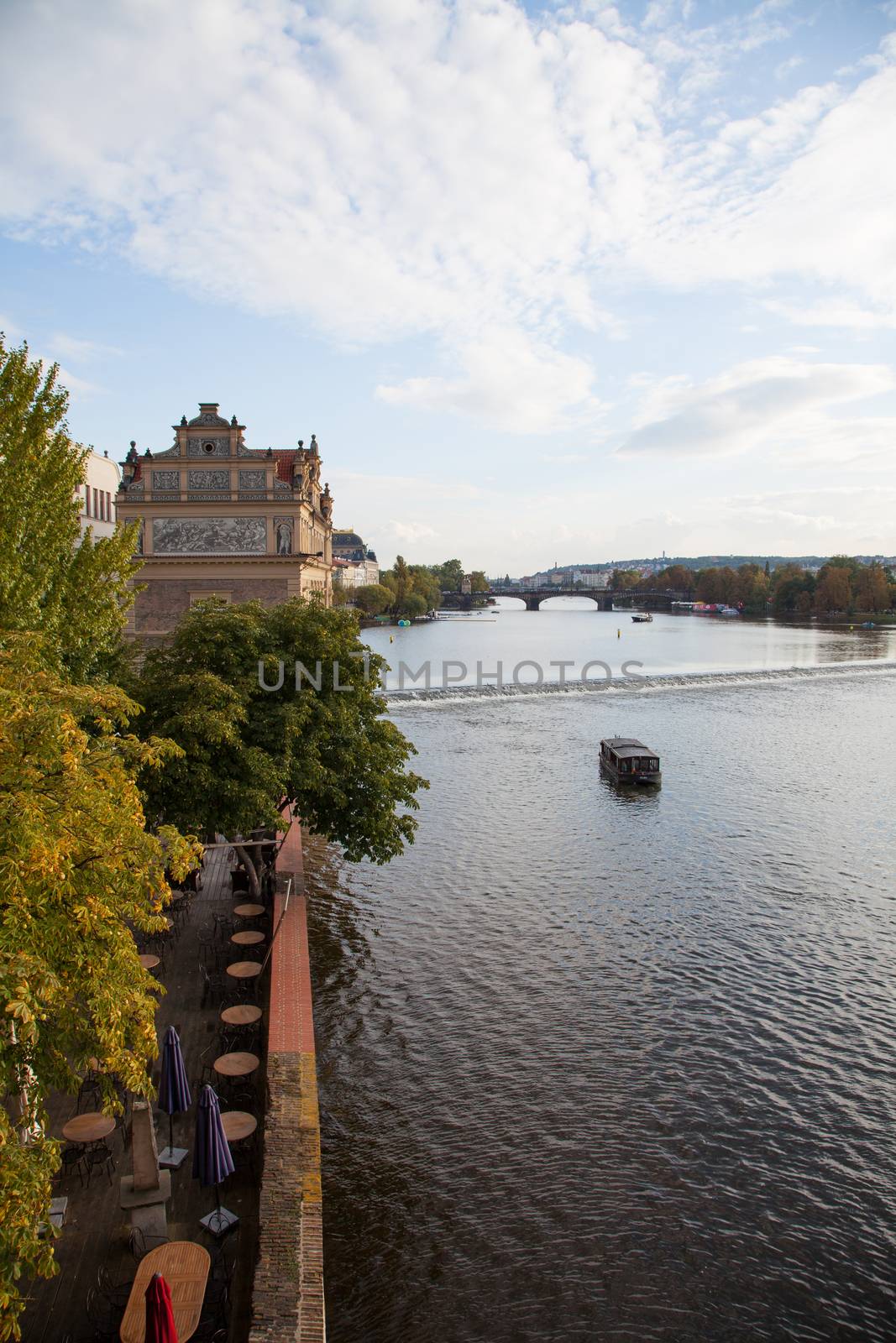 Beautiful Prague City View along the river with tourist boat